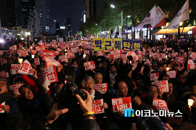 29일 촛불집회 현장, 사람들이 피켓을 들고 '박근혜 퇴진'을 외치고 있다.
