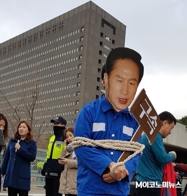 이명박 전 대통령이 지난 14일 서울중앙지검에 소환된 가운데 이날 한 시민단체 회원이 청사 앞에서 이 전 대통령의 구속을 촉구하는 퍼포먼스를 하고 있다. <사진 : 김선재 기자>