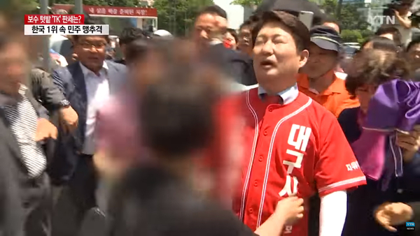 권영진 자유한국당 대구시장 후보가 지난달 31일 낮 대구 중구 반월당네거리에서 출정식을 끝내고 이동하던 중 한 중년여성에 밀려 넘어지고 있다. <사진 : YTN 화면캡쳐>