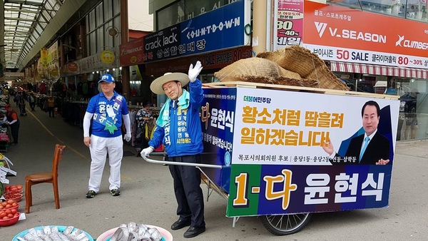 더불어민주당 윤현식 목포시의원 후보가 리어카를 끌고 다니며 이색선거운동을 펼치고 있다.