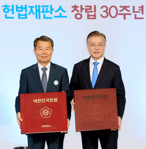 문재인 대통령(오른쪽)과 이진성 헌법재판소장(왼쪽)이 헌법재판소 창립 30주년을 기념하기 위해 제작한 순 한글판 헌법책자를 들고 있다. / 사진 : 헌법재판소