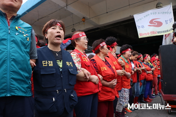 구시장 상인들이 서로의 팔짱을 끼고 집행관의 진입을 막고 있다. <사진 : 박종호 기자>