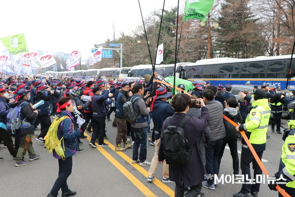 민주노총이 집회 중간, 국회대로의 중앙선을 기점으로한 경찰의 저지선을 뚫고 나가고 있다.