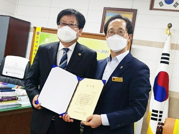 조광희 의원(왼쪽)과 최흥재 안양서중학교장이 감사장을 들고 기념촬영을 하고 있다.