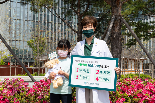 사진 / 유경하 이화의료원장이 서울 가곡초등학교 3학년 장연규 어린이와 함께 4월 21일 “어린이 보호구역 교통안전 릴레이 캠페인”에 참여하고 있다.