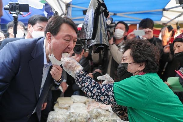 윤석열 국민의힘 대선 후보가 지난 4일 오후 경기 포천 소흘읍 송우리시장을 방문해 떡을 먹고 있다. / 윤석열 국민캠프 제공