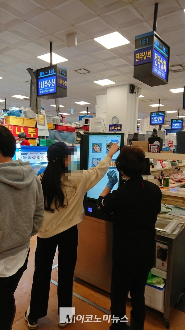 사진/ 손님이 자동주문기에서 주문을 하고 있다.