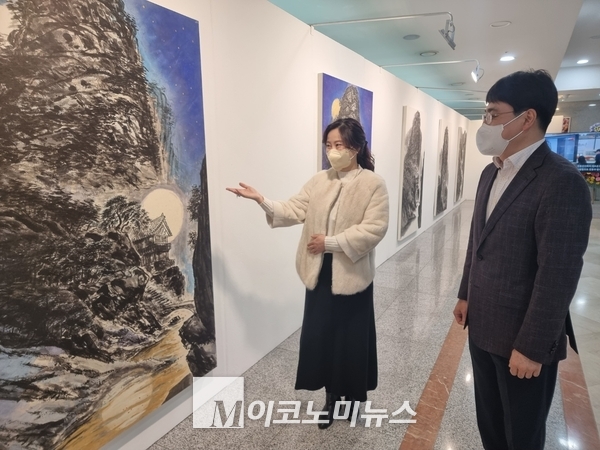 국내 대표 수묵 산수화 작가인 류재춘 작가(왼쪽)가 25일 서울 여의도 국회 의원회관에서 열린 '2021 류재춘 한국화전, 자연의 초상'에서 자신의 작품을 차인혁 CJ올리브네트웍스 대표(오른쪽)에게 소개하고 있다.