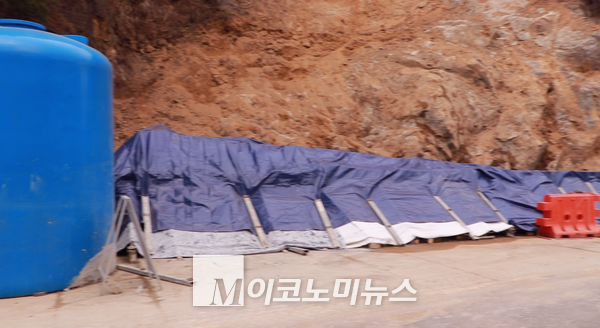 사진/ 경사지고 굽은 도로에 내려온 흙더미를 처리하는 작업이 한창이었다. 