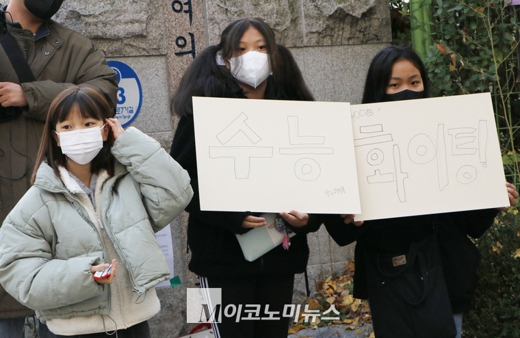 17일 서울 영등포구 여의도여자고등학교에서 2023학년도 대학수학능력시험이 치러지는 가운데 초등학교 5학년생이라고 밝힌 여학생 3명이 '수능 화이팅'이라고 적힌 손피켓을 들고 수험생을 응원하고 있다.