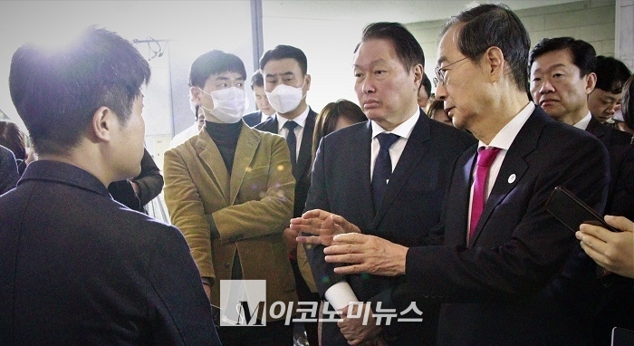 한덕수 국무총리와 최태원 대한상공회의소·SK그룹 회장이 규제 샌드박스 승인기업 물품 전시장에서 기업 관계자에게 설명을 듣고 있다. <사진: 김종현 기자> 