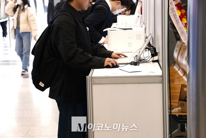 구직자가 박람회장 입구에 비치된 컴퓨터를 이용해 구직정보를 검색하고 있다. <사진: 김종현 기자>