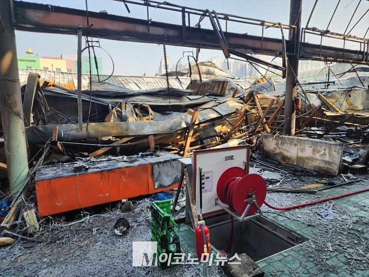 전소된 상점 위로 V자 모형으로 된 철골들이 지지대 위에 위태롭게 걸려 있다. <사진: 김종현 기자>