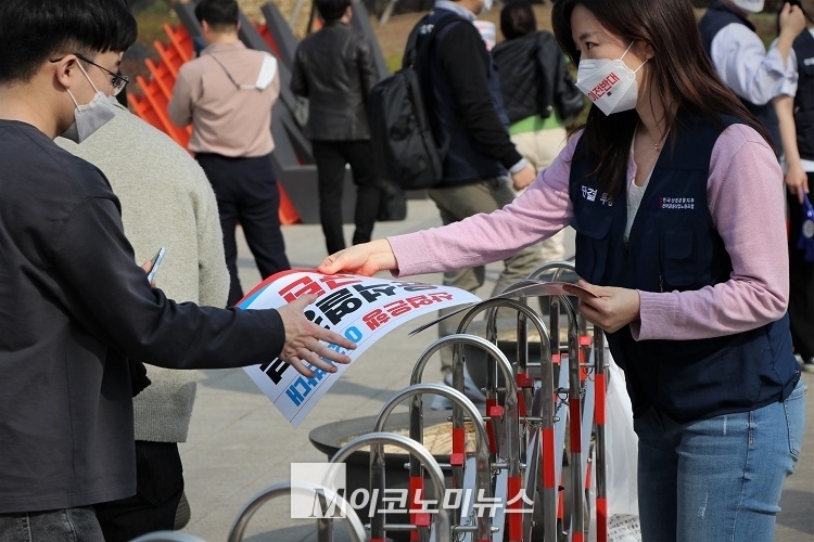 금융노조 산은지부 조합원이 규탄 결의대회에 참가한 이들에게 피켓을 나눠주고 있다. <사진: 김종현 기자>