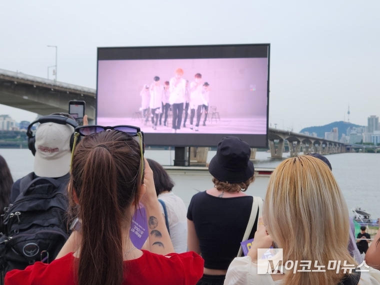 여의도 한강공원에 설치된 대형 화면의 BTS, 공연 장면을 시민들이 스마트폰에 담고 있다. 