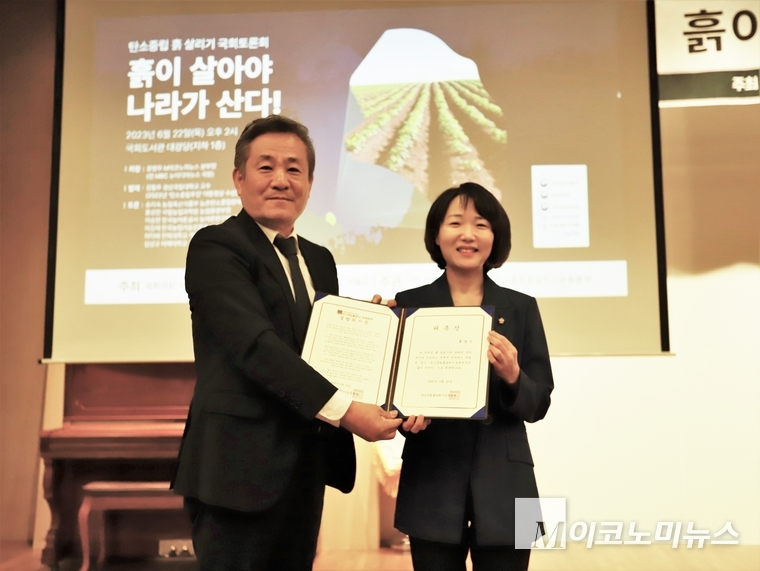 더불어민주당 홍정민 의원이 탄소중립흙살리기운동본부의 조재성 부총재로부터 '흙의 정치인' 위촉을 받고 기념촬영을 하고 있다.