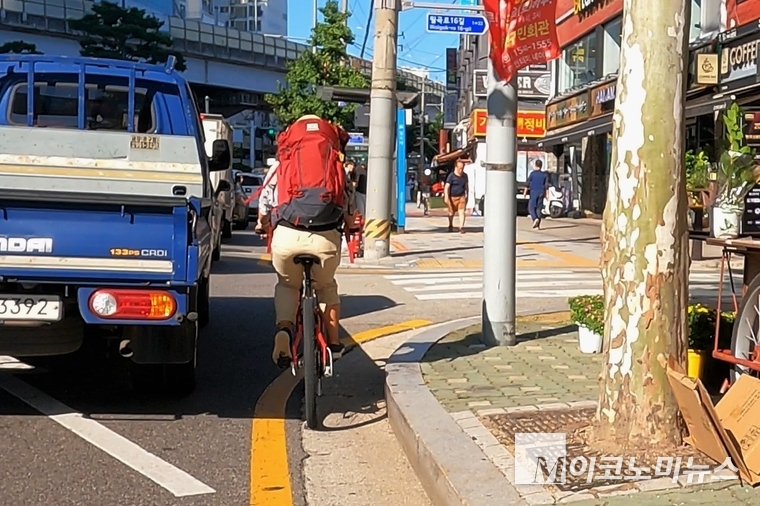 성북구 월곡로를 달리는 김윤정 씨. 서울시내 도로가 대부분 그렇듯이 이곳 역시 자전거가 다닐 수 있는 공간이 없다. 이곳처럼 차도와 보도가 구분된 도로에서 자전거는 보도가 아닌, 차도의 우측 부분을 통행해야 하는데 (도로교통법 제13조 3항) 자전거 통행을 위한 공간이 전혀 없는 이런 곳에서는 치명적인 자전거 사고가 빈번하게 일어나고 있다. 