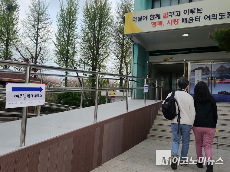 제22대 국회의원 선거일인 10일 오전 서울 영등포구 여의도중학교에 마련된 제4투표소로 젊은 부부가 소중한 한 표를 행사하기 위해 들어가고 있다. 