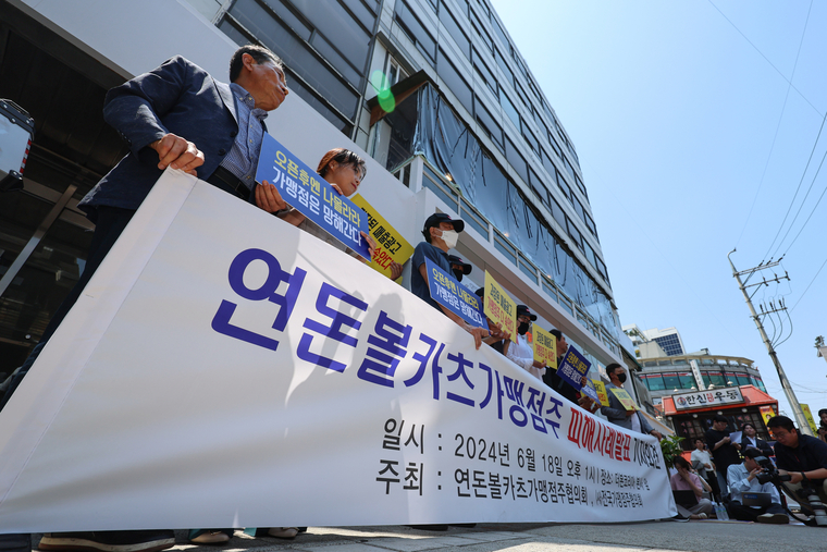 연돈볼카츠가맹점주협의회와 전국가맹점주협의회 관계자들이 18일 오후 서울 강남구 더본코리아 본사 앞에서 연돈볼카츠 가맹점 피해사례 발표 기자회견을 하고 있다. 연합뉴스 