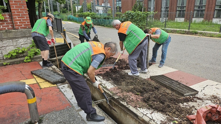 의왕시 지역자율방재단이 다가오는 장마철을 대비해 도로변 빗물받이 등을 점검하고 있다 <의왕시 제공>