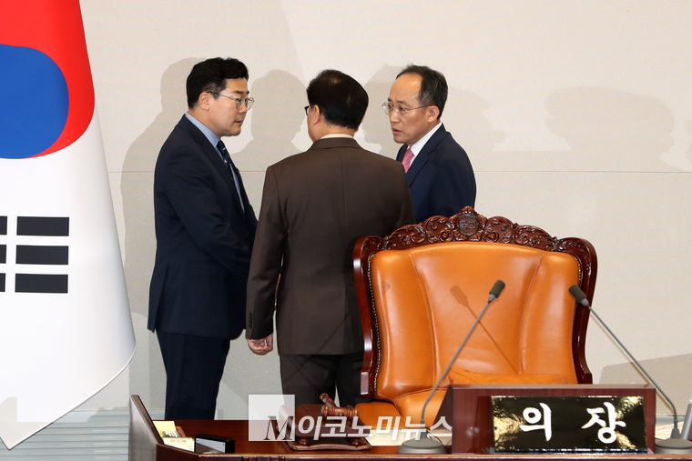 박찬대 더불어민주당 당대표 직무대행 겸 원내대표(왼쪽)와 추경호 국민의힘 원내대표가 3일 우원식 국회의장을 사이에 두고 이야기를 나누고 있다.