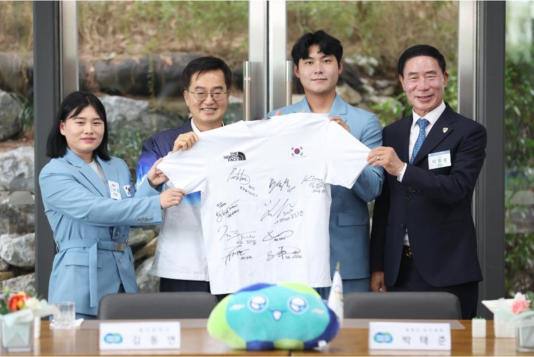 20일 오전 도담소에서 열린 2024 제33회 파리올림픽 경기도 선수단 환영식에서 김동연 경기도지사가 선수단에게 선수단 사인 티셔츠를 선물 받고 기념촬영을 하고 있다 <경기도 제공>