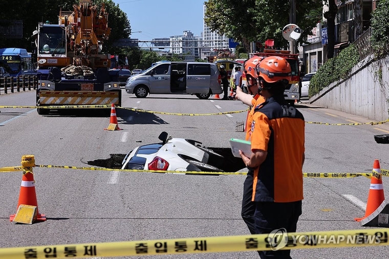 29일 오전 서울 서대문구 연희동 성산로에서 땅 꺼짐 사고로 승용차가 빠져 있다. 이 사고로 승용차 탑승자들이 병원으로 후송됐다. (사진=연합뉴스)