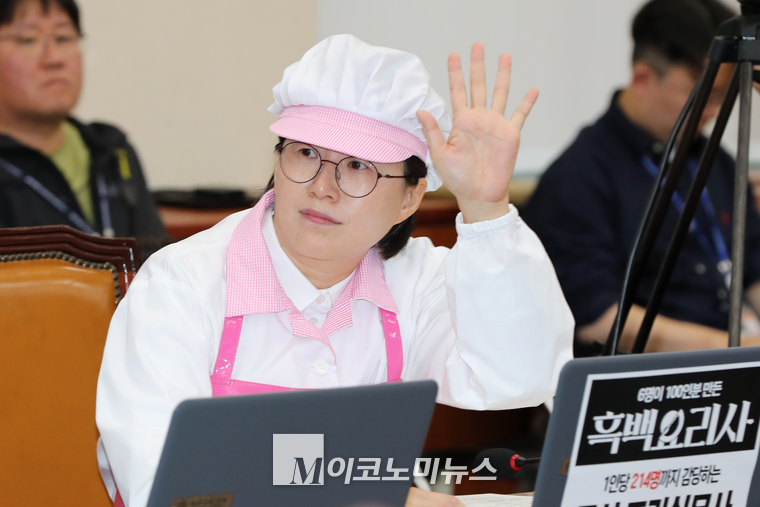 정혜경 진보당 의원이 급식 조리사 복장을 착용하고 국감장에 참석해 으시진행 발언을 위해 거수하고 있다. (사진=최동환 기자)