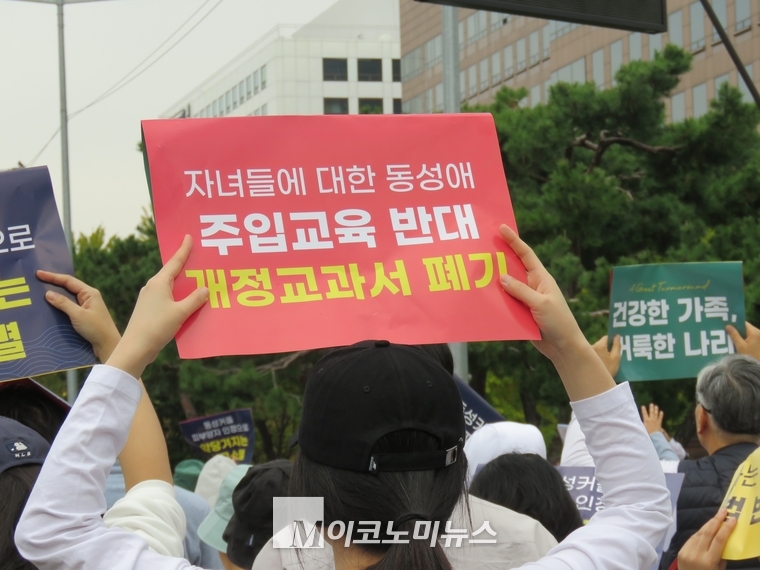 집회 참가자가 주입교육 반대, 개정교과서 폐기 등의 문구가 쓰인 피켓을 들고 있다.