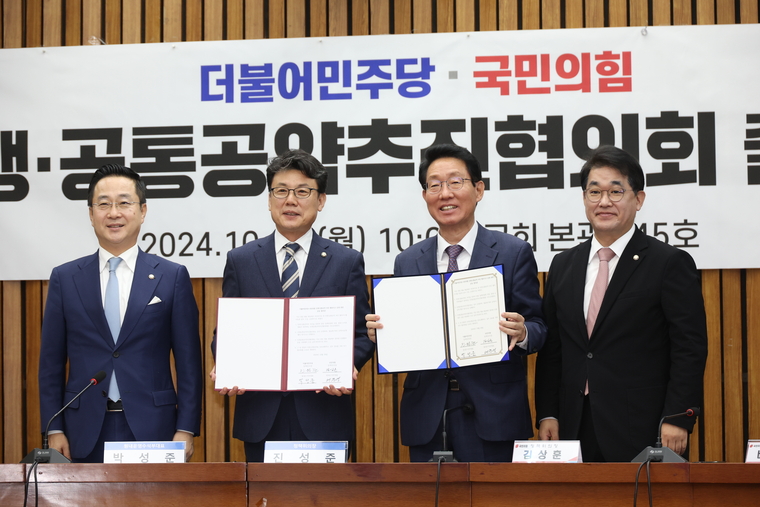 ,더불어민주당 박성준 원내수석부대표, 진성준 정책위의장, 국민의힘 김상훈 정책위의장, 배준영 원내수석부대표가 28일 국회에서 열린 민주당-국민의힘 민생·공통 공약 추진 협의기구 출범 회당에서 합의문에 서명한 뒤 취재진을 향해 포즈를 취하고 있다. (연합뉴스)