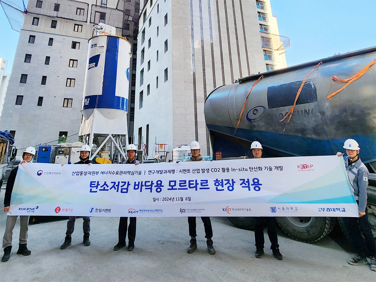 롯데건설이 지난 6일 한일시멘트와 함께 개발한 ‘CO₂(이산화탄소) 주입 바닥용 모르타르’ 기술을 현장에 적용하고 기념사진을 촬영하고 있다. 사진=롯데건설 