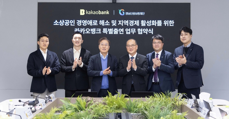카카오뱅크 윤호영 대표이사(왼쪽 세 번째)와 경남신용보증재단 이효근 이사장(오른쪽 세 번째)이 지난 27일 카카오뱅크 판교오피스에서 열린 '카카오뱅크 특별출연 업무 협약식'에 참여해 임직원들과 함께 기념 촬영을 하고 있다. 카카오뱅크 제공