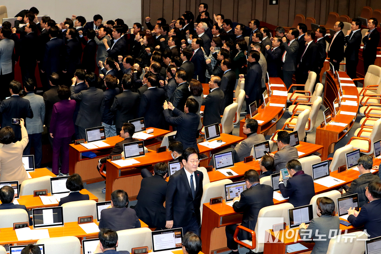 이재명 더불어민주당 대표가 지난 27일 국회 본회의에서 한덕수 국무총리 탄핵소추안에 투표를 두고 국민의힘 의원들이 우원식 국회의장에게 항의하는 동안 투표 후 자리로 향하고 있다. (사진=최동환 기자)
