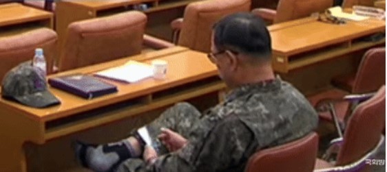 국방부 긴급 현안질의 정회 중 스마트 게임을 하고 있는 공군 소장. 국회방송 캡처