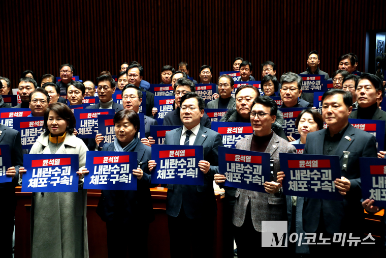 더불어민주당이 4일 국회 본청에서 비상 의원총회를 열고 “윤석열 내란수괴 체포구속”이라 피켓팅하며 구호를 외치고 있다. 사진=최동환 기자