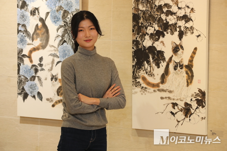 작품 앞에서 포즈를 취하고 있는 김명신 작가. 사진 최동환 기자 