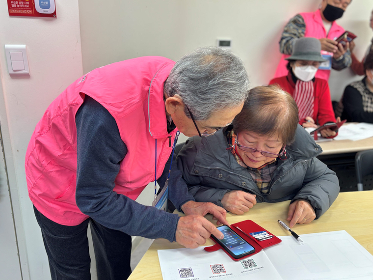 수강생(왼쪽) 어르신이 보조강사로 활동하며 우리 어르신 IT 행복 배움교실 수업 수강생들을 돕고 있다. 사진=우리금융미래재단