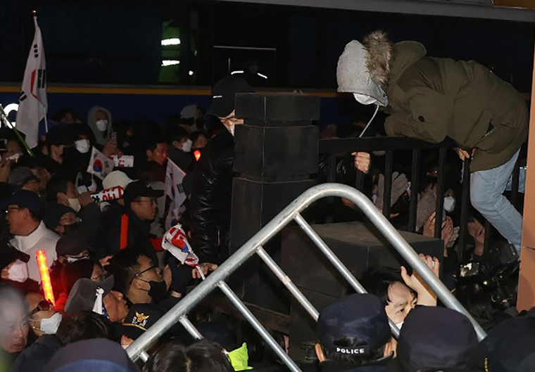 내란 우두머리 혐의로 체포된 윤석열 대통령이 출석한 가운데 구속 전 피의자심문(영장실질심사)이 열린 18일 서울 마포구 서울서부지법에서 윤 대통령 지지자들이 법원 담장을 넘어왔다가 다시 밖으로 나가고 있다. 사진=연합뉴스/공동취재