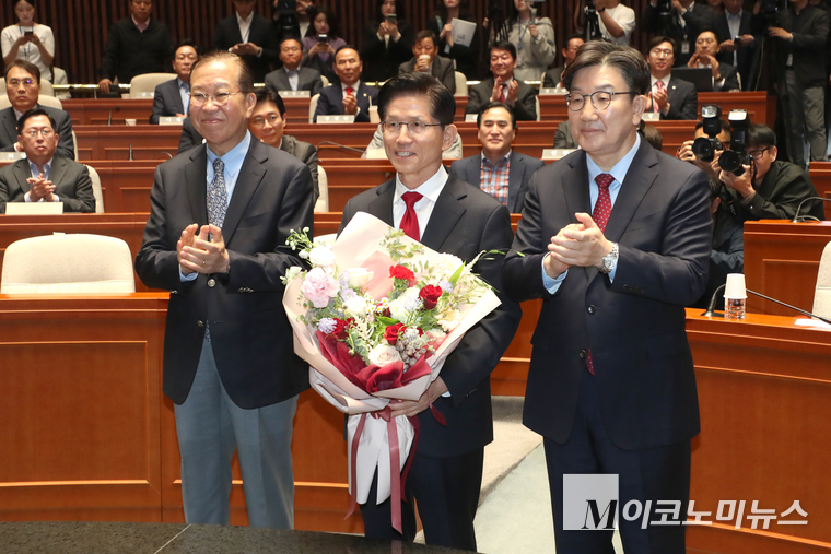 김문수 국민의힘 대선 후보가 9일 국민의힘 의원총회에 참석해 권영세 비대위원장과 권성동 원네대표로부터 꽃다발을 선물 받고 있다. 사진=최동환 기자