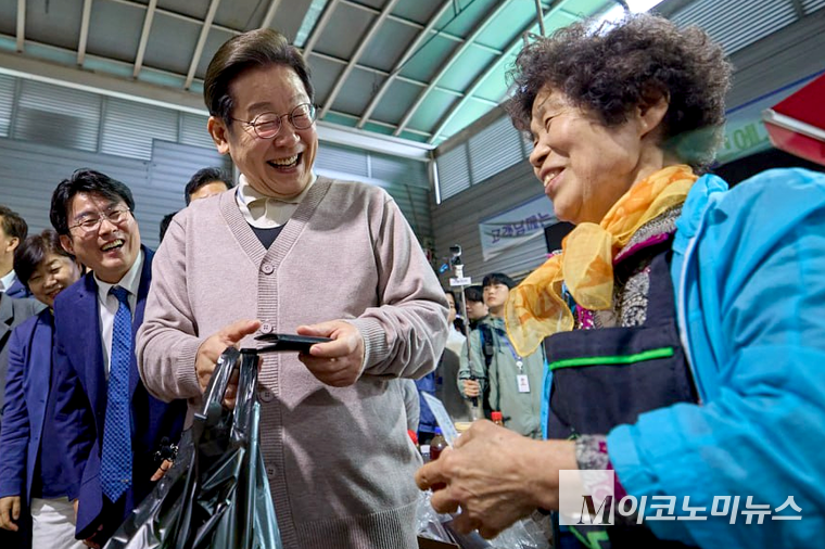 이재명 더불어민주당 후보가 경청투어에서 시장을 찾아 상인들과 웃으며 이야기하고 있다. 사진=더불어민주당