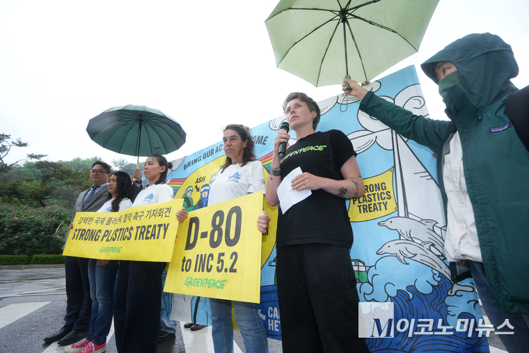국제환경단체 그린피스 서울사무소가 16일 서울중앙지방법원 앞에서 기자회견을 열고, 그린피스 인터내셔널 액티비스트와 그린피스 레인보우워리어호 헤티 기넨 선장이 강력한 국제 플라스틱 협약을 촉구하는 배너를 들고 있다. 사진=최동환 기자