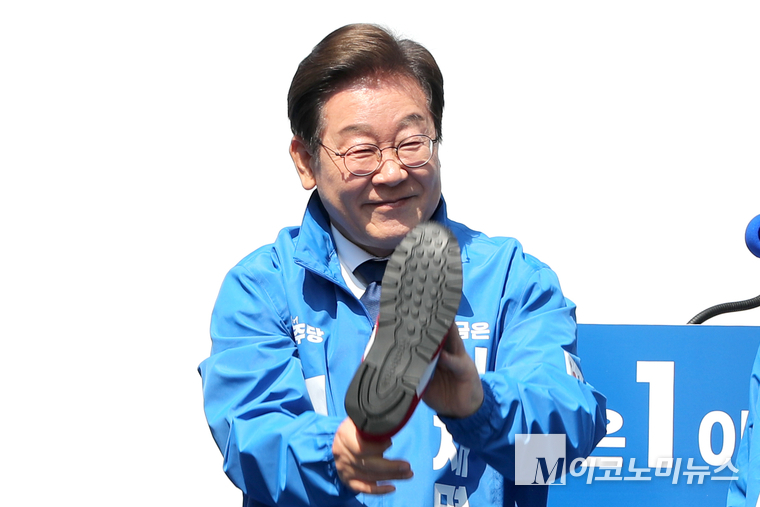 이재명 더불어민주당 대통령 후보가 제21대 대통령선거 공식 선거운동이 시작된 지난 12일 오전 청계광장에서 열린 중앙선거대책위원회 출정식에서 새 운동화를 들고 미소 짓고 있다. 사진=최동환 기자
