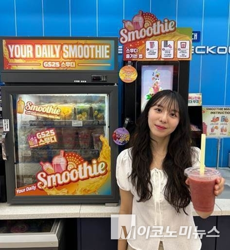 한 고객이 GS25에서 판매하는 ‘생과일 스무디’를 들고 포즈를 취하고 있다. 사진=GS리테일 
