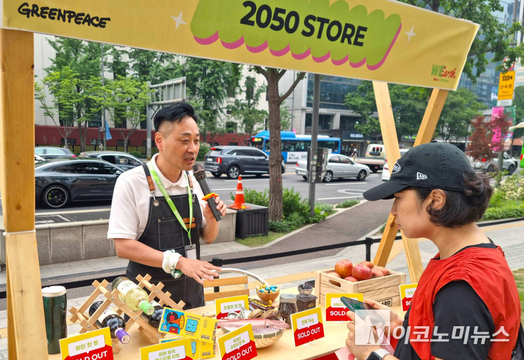 ‘2050스토어’에서 기후위기로 인해 아메리카노, 초콜릿, 와인, 오징어, 전복, 사과 등을 살 수 없게 되는 미래를 간접 체험하며 기후위기가 일상에 미치는 영향을 실감하는 시민. 사진=그린피스