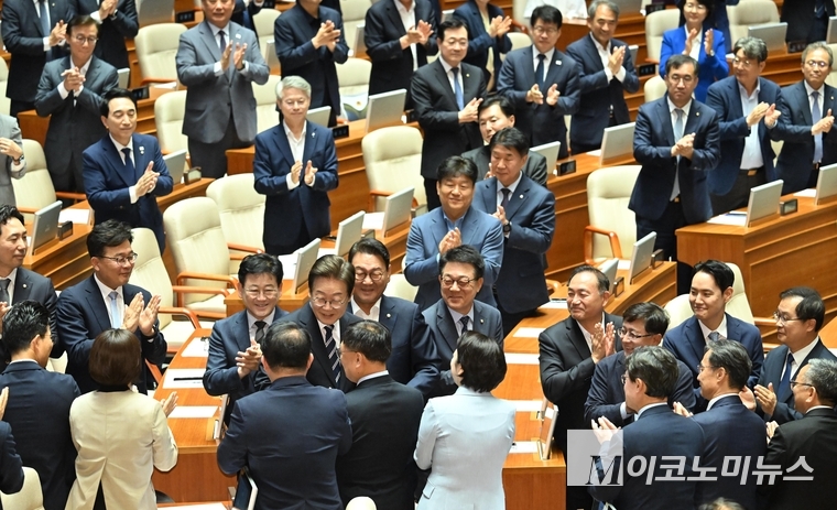 이재명 대통령이 26일 국회 본청 본회의장에서 추가경정예산안 시정 연설 후 민주당 의원들과 인사하고 있다. 사진=공동취재단