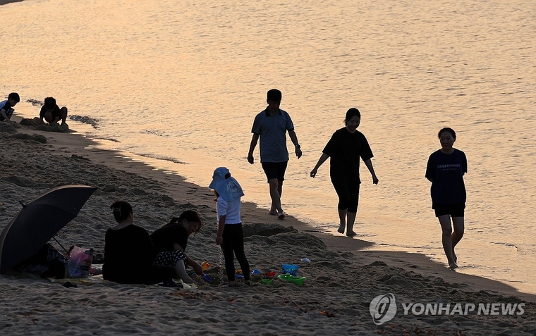 29일 강원 강릉지역에 열대야가 예고된 가운데 시민들이 안목해변에서 바닷물에 발을 담그거나 바닷바람을 맞으며 무더위를 식히고 있다. 사진=연합뉴스