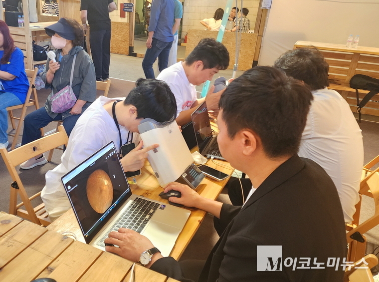 '2025 포트빌리지 부산' 행사에서 대웅제약 부스 방문객이 AI 실명질환 진단 보조 솔루선 '위스키'와 안저 카메라 '옵티나'를 활용해 안저 상태를 확인하고 있다. 사진=대웅제약