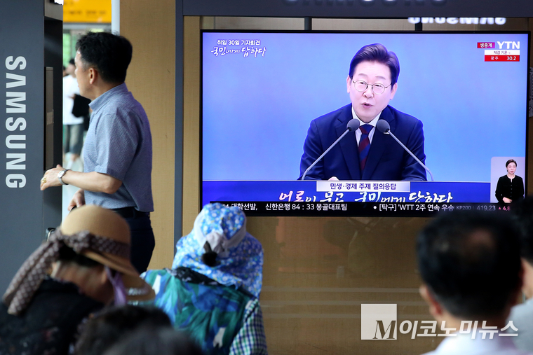 이재명 대통령이 취임 30일을 맞은 3일 기자회견 모습을 서울역 대합실에 모인 시민들이 지켜보고 있다. 사진=최동환 기자