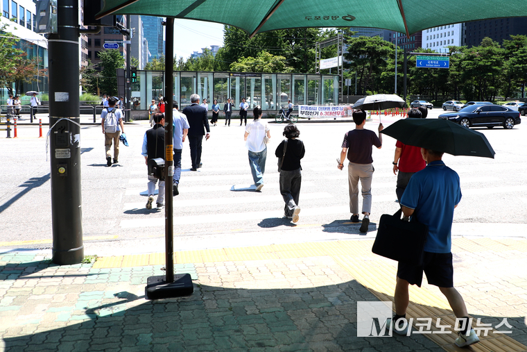 서울 여의도 국회에는 점심 시간을 맞아 직장인과 시민들이 하나, 둘 양산을 펼치고 그늘을 찾아 이동하고 있다. 사진=최동환 기자
