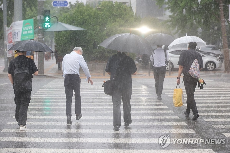 서울 영등포구 여의도 국회 인근에서 시민들이 우산을 쓰고 이동하고 있다. 사진=연합뉴스